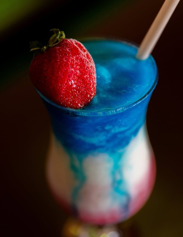 Cóctel azul, blanco y rojo con fresa