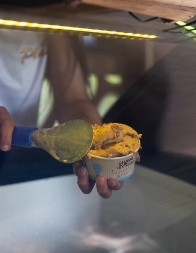 Tarrina de helado servida con cuchara de bola